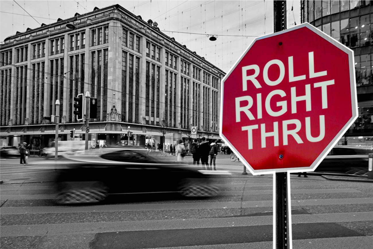 Black and white city photo featuring red stop sign reading 