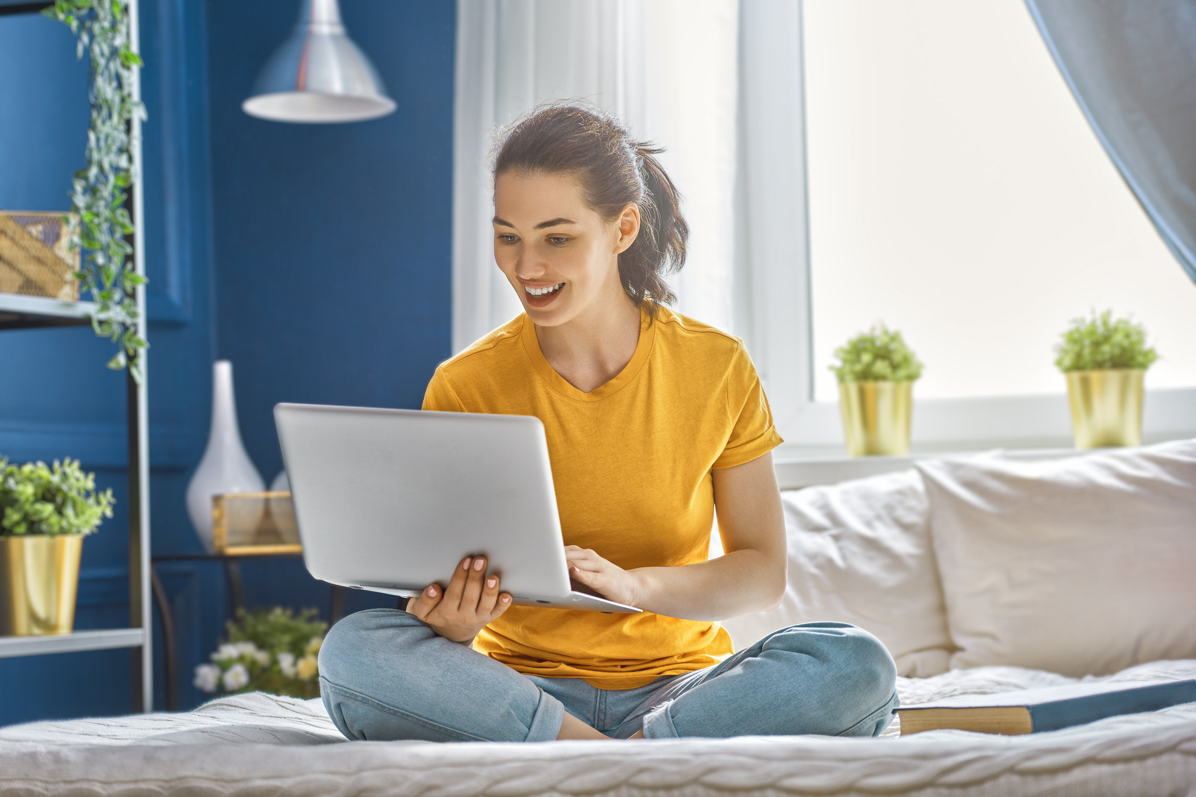 Image description: Person using laptop at home to search for down payment assistance programs