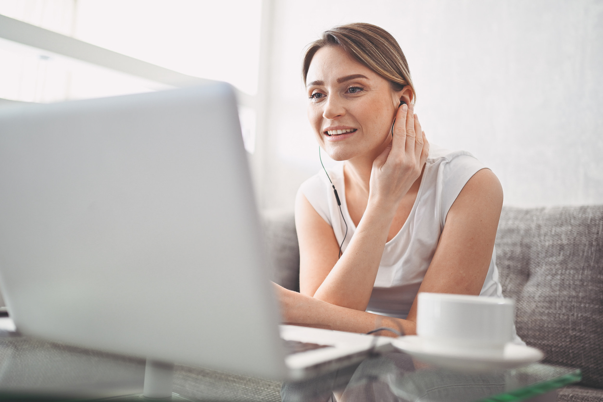 Image description: Person watching virtual townhall on her laptop at home.