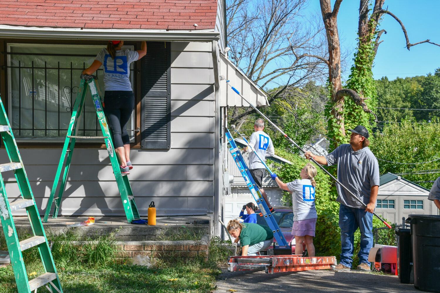Image description: Realtors paint a home at Rock the Block.