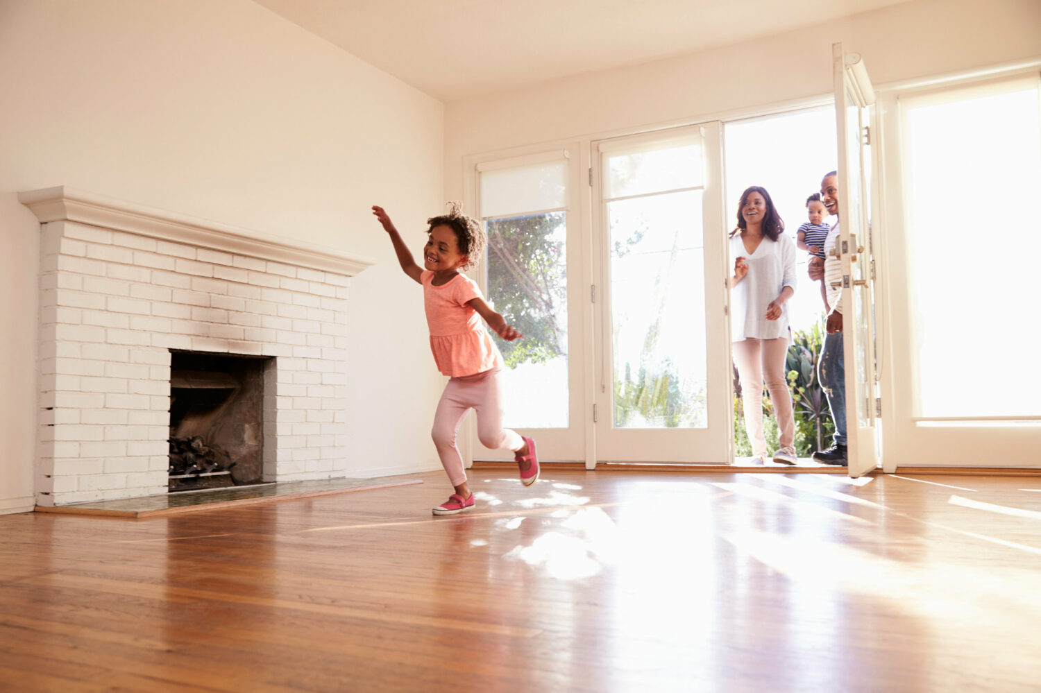 Image description: Excited Family Explore New Home On Moving Day