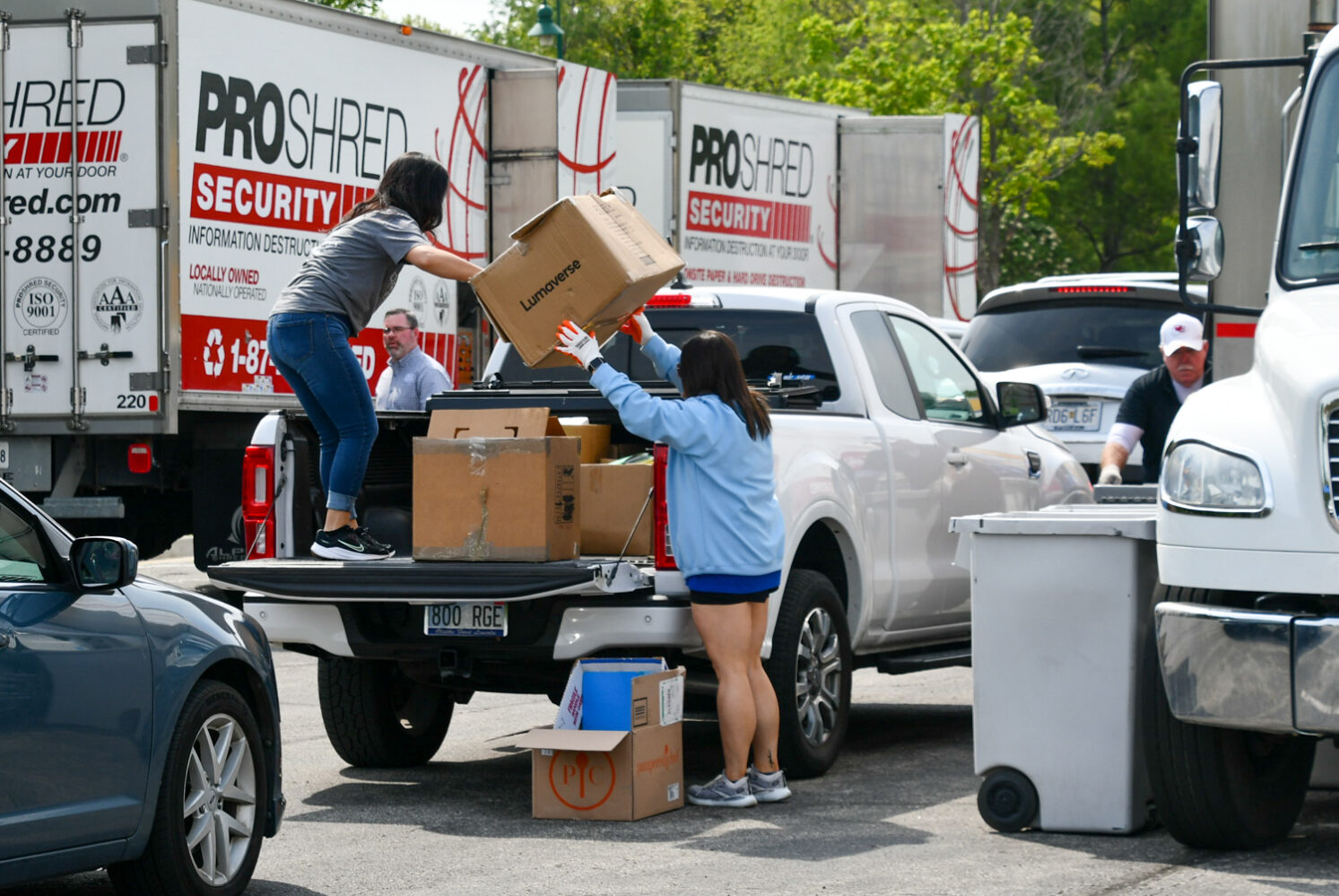 Image description: Volunteers work on unloading a truck at Shred Day 2023.